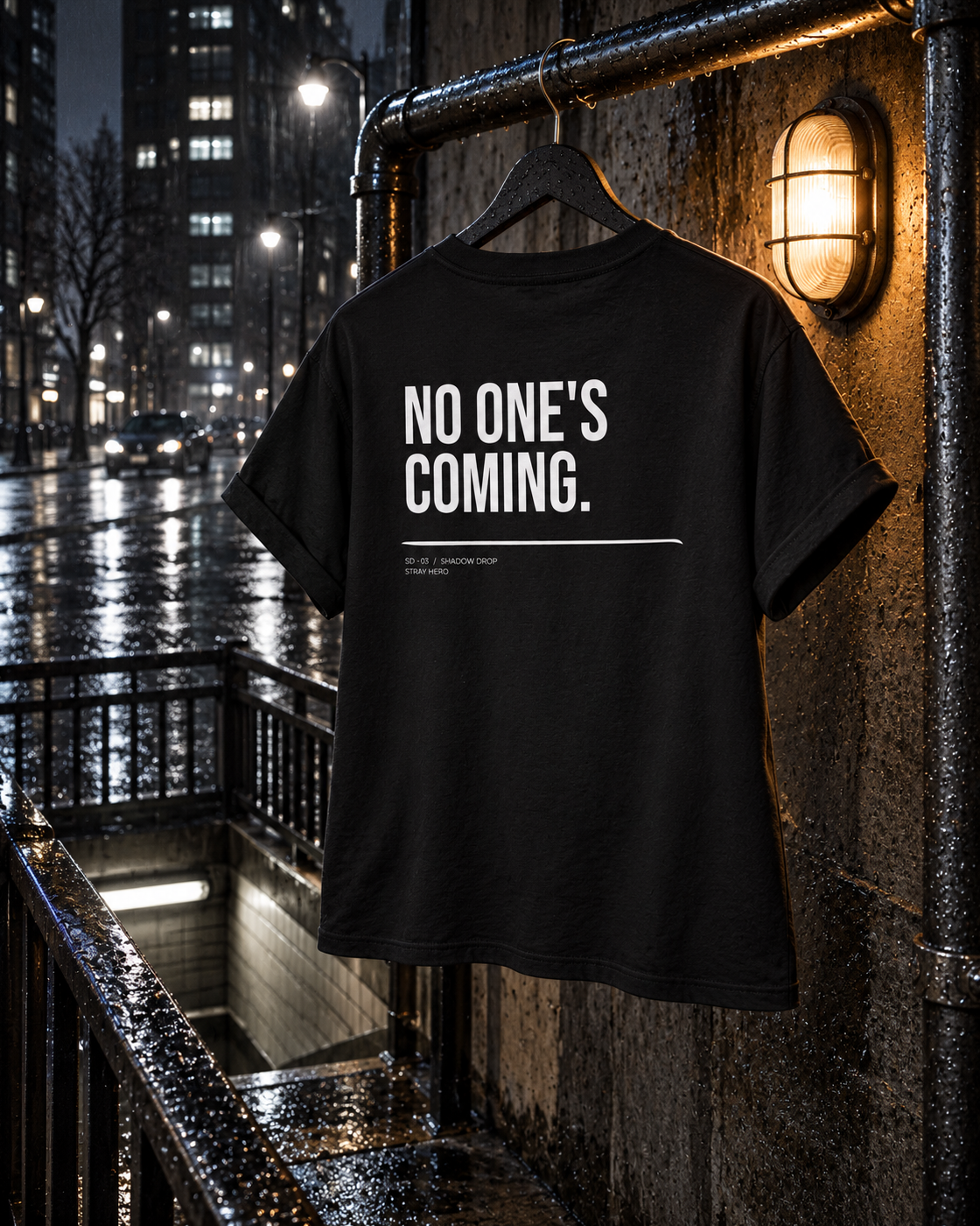 No One's Coming Women's Tee, back print, black, hanging on a railing under a wall lamp at night — AI-generated visual