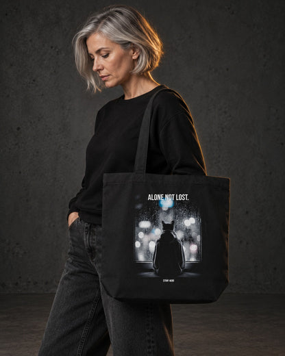 Alone Not Lost Organic Tote, carried, back print, black — AI-generated visual