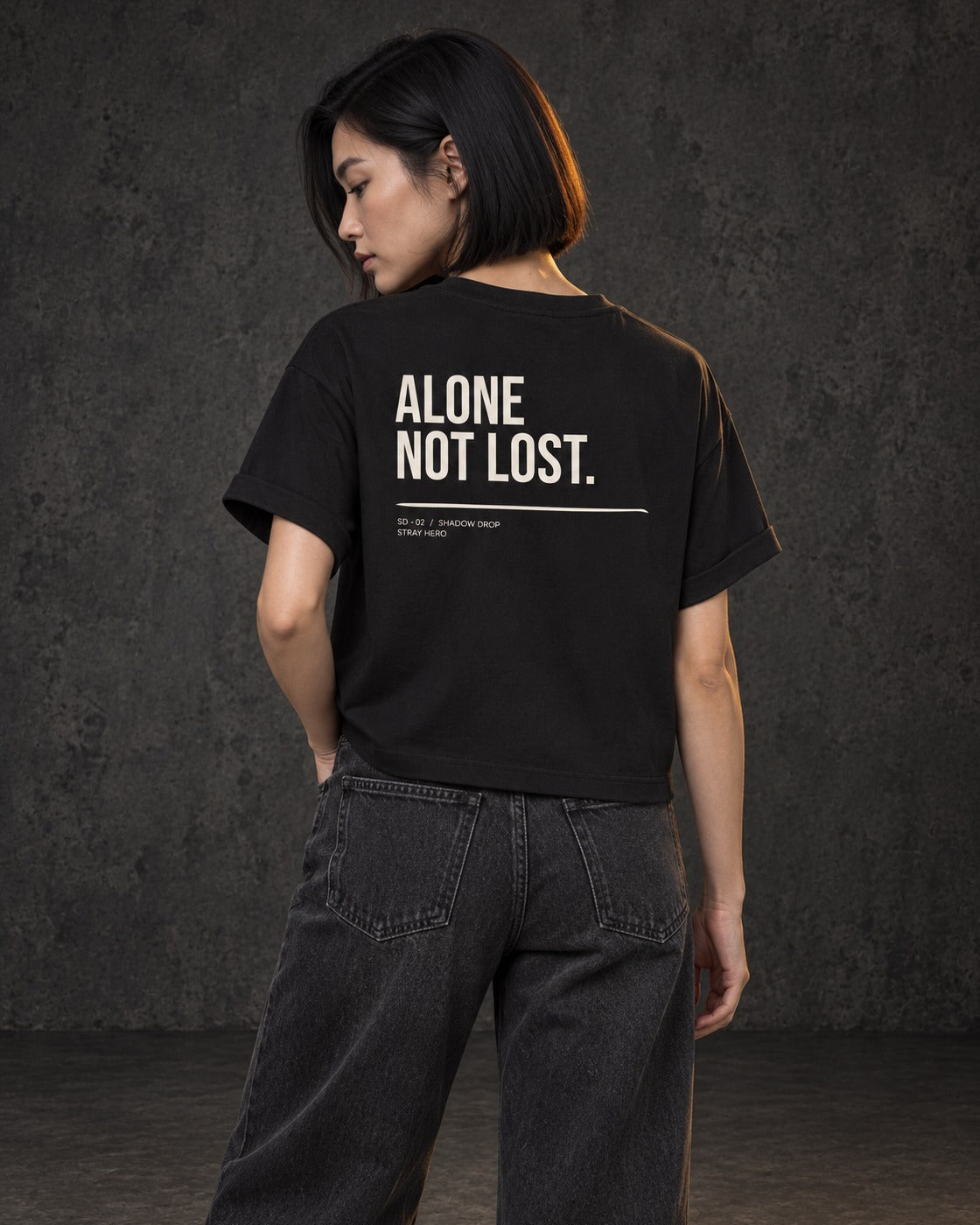Alone Not Lost Women's Tee, worn, back print, black — AI-generated visual
