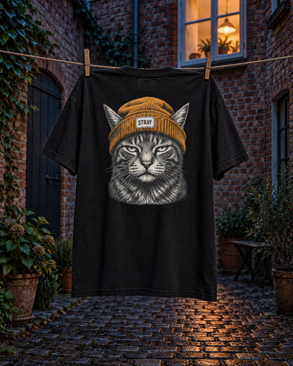 Beanie Cat Tee Ember, back print, black, pegged on a clothesline in a brick courtyard at dusk — AI-generated visual