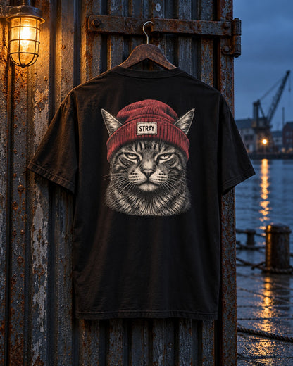 Beanie Cat Tee Rogue, back print, black, hanging on a rusted door at the harbour with cranes behind at night — AI-generated visual