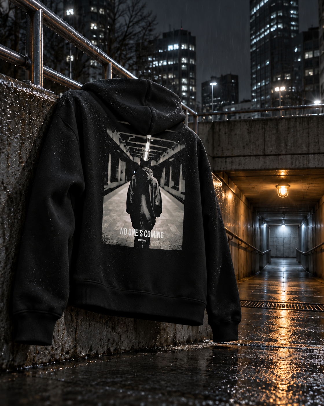 No One's Coming Hoodie Cinematic, back print, black, draped over a railing at an underpass entrance — AI-generated visual