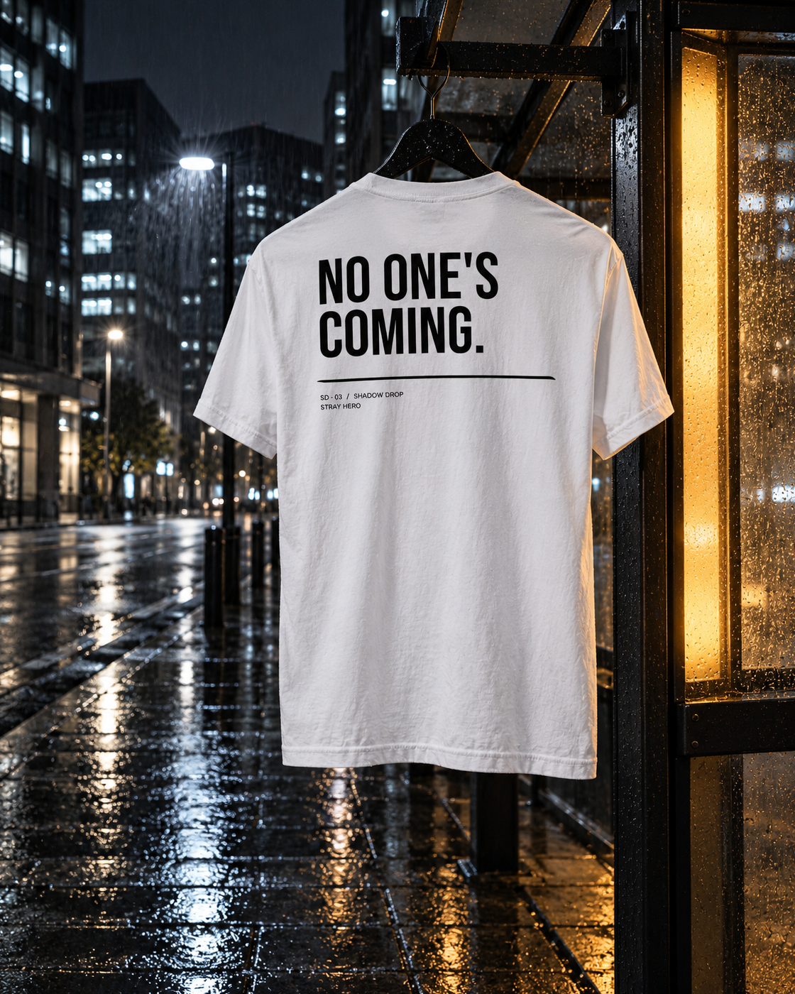 No One's Coming Tee White, back print, white, hanging at a bus shelter under a lamp — AI-generated visual