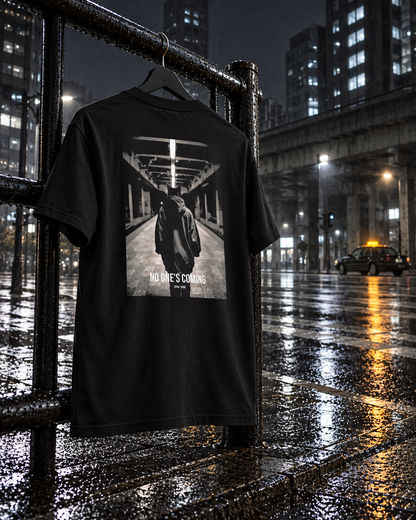 No One's Coming Tee Cinematic, back print, black, hanging on a railing on a rainy street at night — AI-generated visual