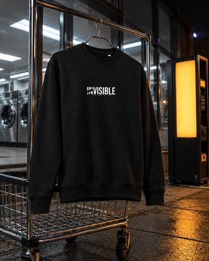 Invisible Sweatshirt, front print, black, hanging on a laundry cart in a laundromat — AI-generated visual