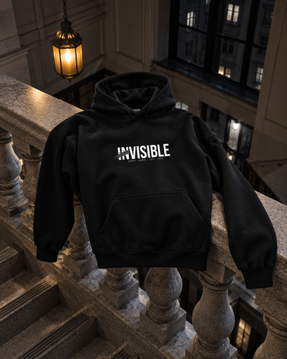 Invisible Hoodie, front print, black, draped over a stair railing in a stairwell — AI-generated visual