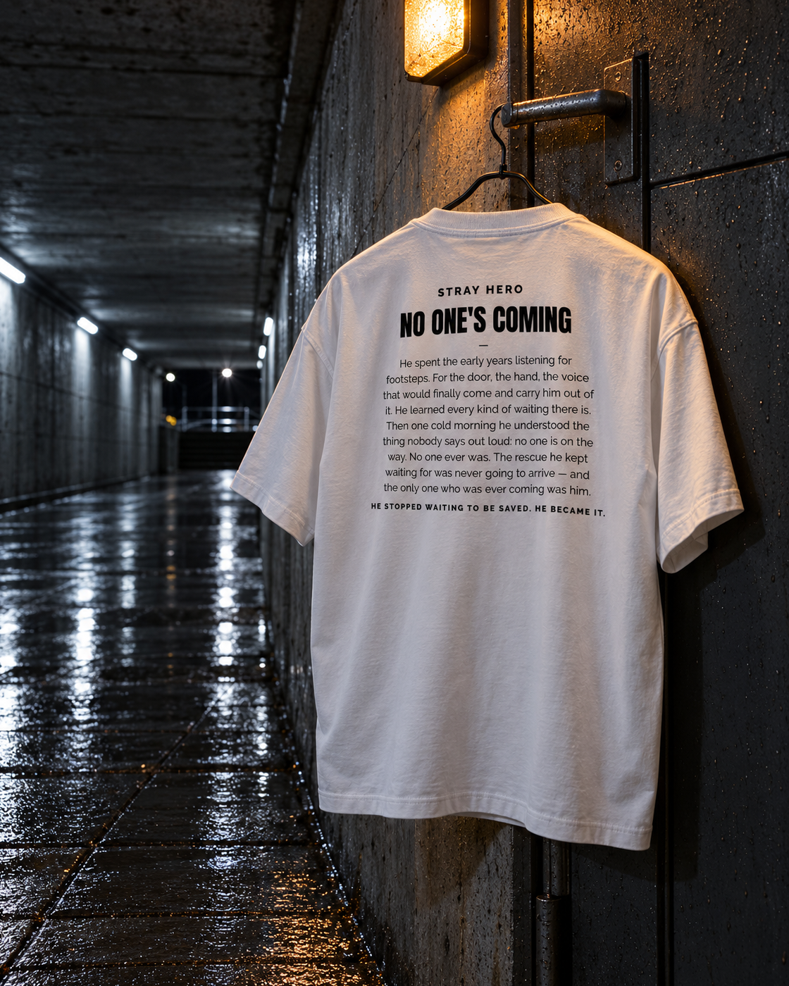 No One's Coming Story Tee White, back print, white, hanging on a wall hook in an underpass — AI-generated visual
