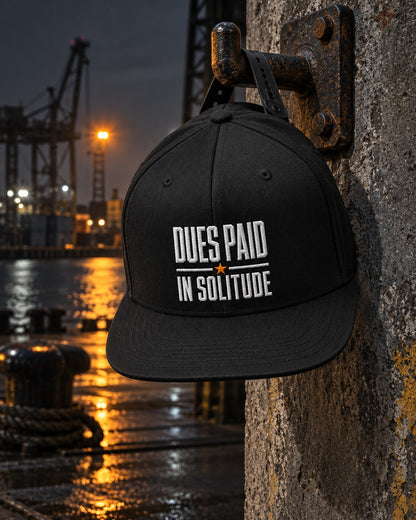 Loners Union Snapback, front embroidery, black, hanging from an iron hook on a quay wall with cranes behind at night — AI-generated visual