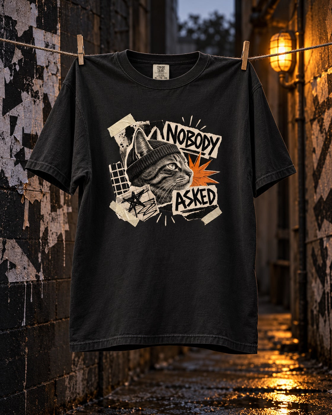 Nobody Asked Tee, front print, black, pegged on a clothesline in a graffiti alley at night — AI-generated visual