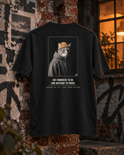 Portrait No. 01 Tee, back print, black, hanging on a graffiti-covered brick wall beside a lit window at dusk — AI-generated visual