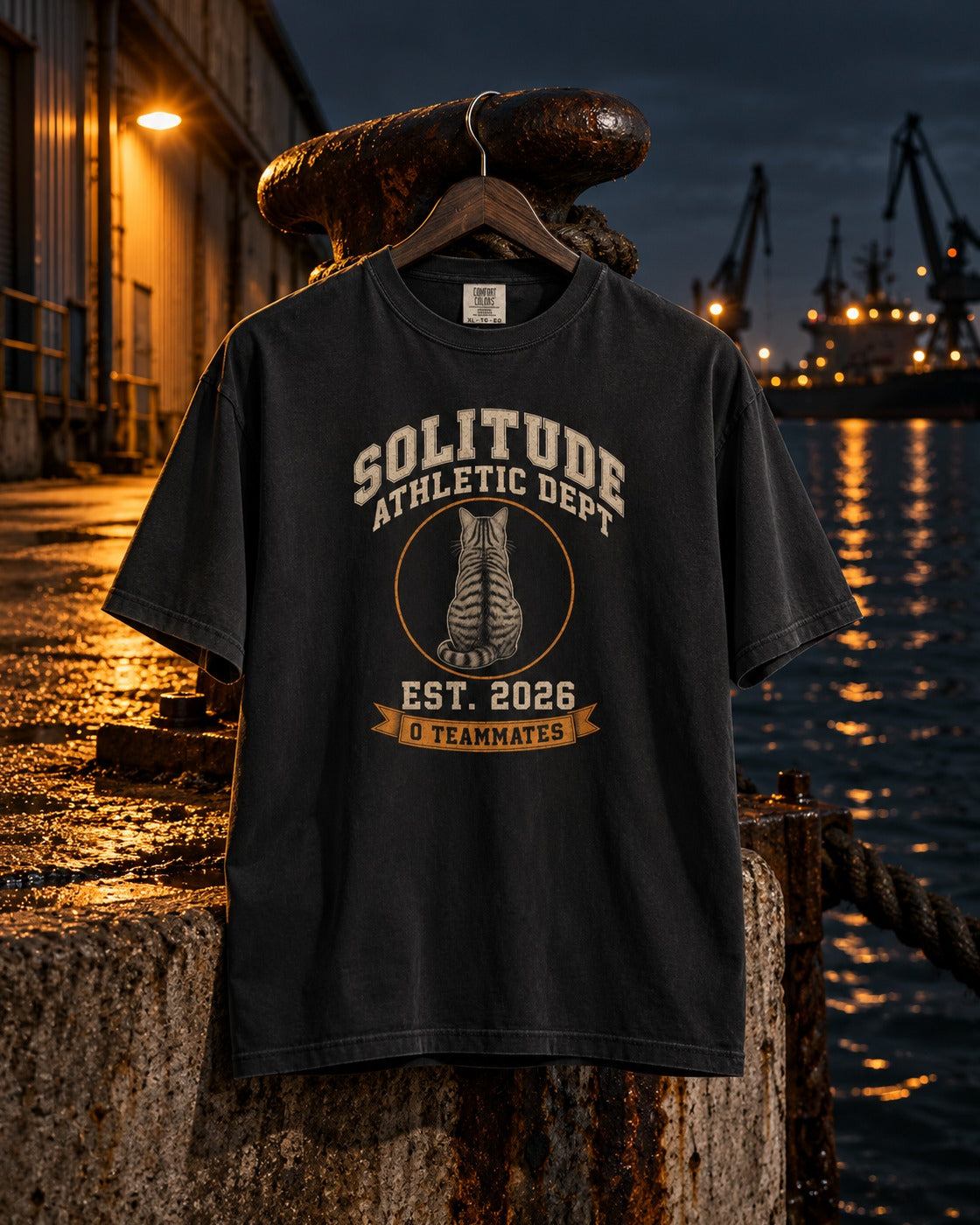 Solitude Athletic Dept. Tee, front print, black, hanging on a rusty bollard at the harbour at night — AI-generated visual