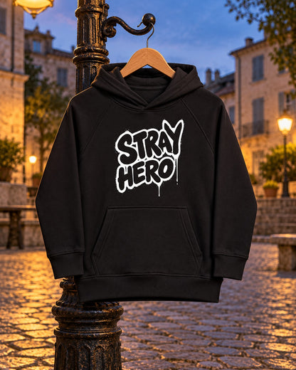 Stray Hero Kids Graffiti Hoodie, front print, black, hanging on a lamppost in a cobbled square at dusk — AI-generated visual